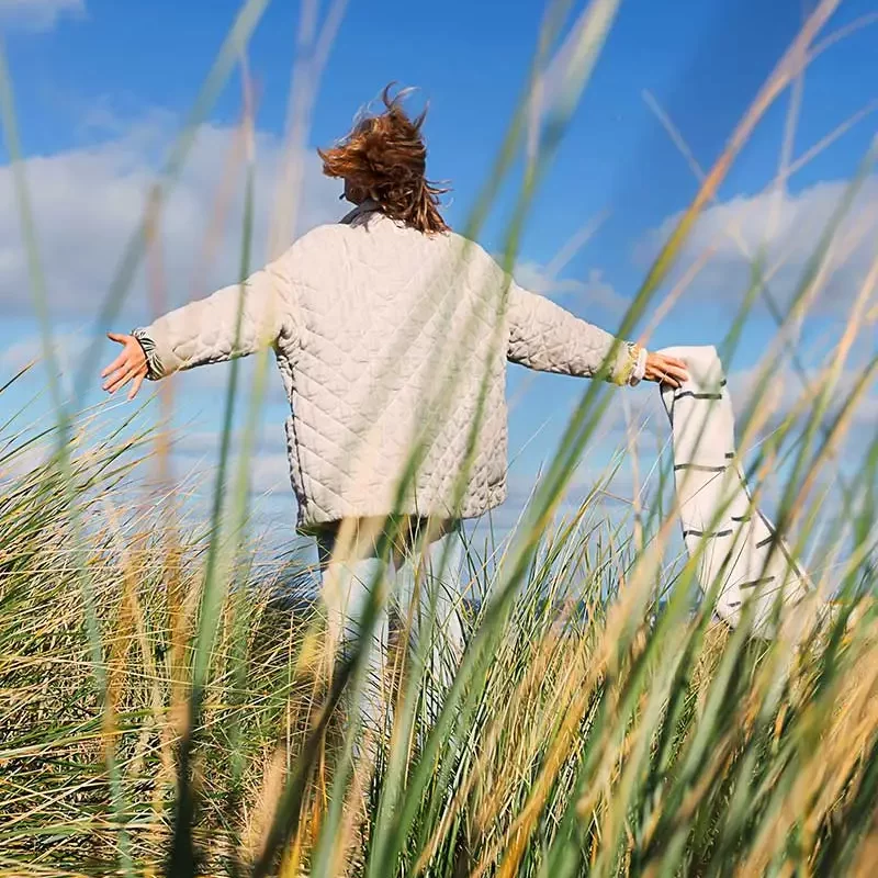 woman free in a field of grass after being a new patients at charter psychiatry